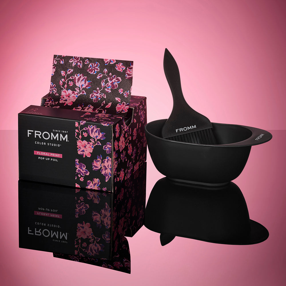 Black hair color mixing bowl and floral packaging with 'FROMM' branding on a pink background